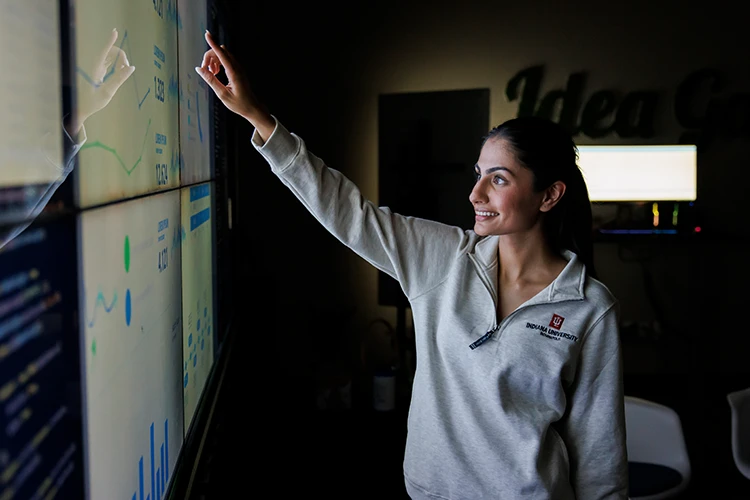 A student pointing to something on a large screen
